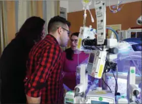  ?? TYLER RIGG — THE NEWS-HERALD ?? Taylor Voelker and her husband, Ray, visit NICU infant patients to deliver donated book and teddy bear sets.