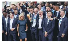  ?? Reuters; EPA ?? The France squad meet the French President Emmanuel Macron and his wife Brigitte yesterday and, main image, parading down the Champs-Elysees