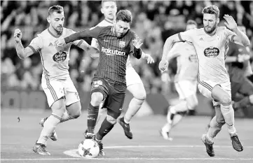  ??  ?? Barcelona’s Argentinia­n forward Lionel Messi (centre) vies with Celta Vigo’s Spanish defender Jonny Castro (left) and Celta Vigo’s Spanish defender Sergi Gomez (right) during the Spanish Copa del Rey (King’s Cup) round of 16 second leg football match...