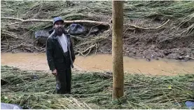  ?? The Maui News / KEHAULANI CERIZO photo ?? Haiku resident Bill Pinkard on Tuesday stands amid the debris left behind by a swollen river. Pinkard lost two vehicles, work tools, a freezer and other belongings get swept away Monday.