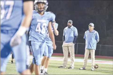  ?? (River Valley Democrat-Gazette/Hank Layton) ?? Lucious Selmon III (second from right), defensive line coach for Fort Smith Southside, visits with head coach Kim Dameron on Thursday before a game against Springdale at Jim Rowland Stadium in Fort Smith.