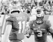  ?? JOSEPH GARNETT JR./GETTY ?? USF quarterbac­k Blake Barnett, left, celebrates with teammate wide receiver Darnell Salomon after they teammed up for a touchdown in a 20-13 win over East Carolina.