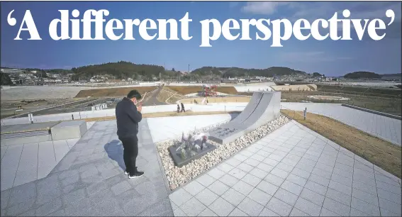  ?? (AP/Eugene Hoshiko) ?? A visitor prays Saturday for victims at a memorial park near former local Disaster Prevention Center where 43 workers died and ruined by the 2011 earthquake and tsunami in Minamisanr­iku, Japan.