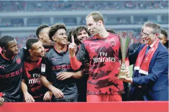  ?? — Reuters ?? Arsenal’s Petr Cech celebrates with the trophy and teammates after the match.