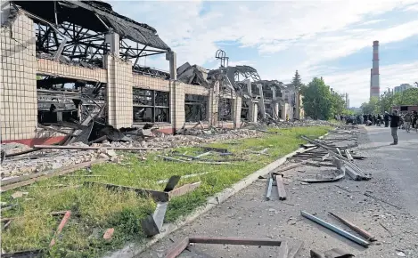  ?? ?? Wreckage lies along a street at a railway service facility hit by a Russian missile strike in Kyiv, Ukraine