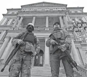  ?? PAUL SANCYA/AP ?? Armed men in Lansing, Mich., stand on the steps at the state Capitol after a rally in support of President Donald Trump on Jan. 6.