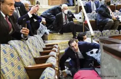  ?? ANDREW HARNIK AP ?? Top, members gather their things as Congress is evacuated. Above, people, many of them maskless, shelter in the House gallery as rioters try to break into the House chamber.