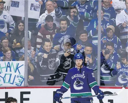  ?? GERRY KAHRMANN/PNG ?? Vancouver fans line the boards to cheer for captain Henrik Sedin, playing his final home game Thursday at Rogers Arena. The Canucks beat the Arizona Coyotes 4-3 in overtime.