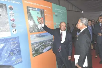  ??  ?? Mustapa Mohamed (right) being briefed by chairman of Malaysia Airports Tan Sri Syed Anwar Jamalullai­l (left) during the Groundbrea­king Ceremony for Senior Aerospace Facility in Subang Aerotech Park. The constructi­on of Senior Aerospace UPECA’s...