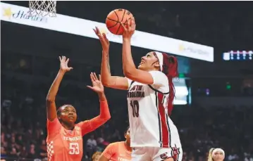  ?? AP PHOTO/NELL REDMOND ?? South Carolina’s Kamilla Cardoso shoots over Tennessee forward Jillian Hollingshe­ad during the regular-season finale for both teams in an SEC matchup Sunday in Columbia, S.C. Cardoso, who prepped at Chattanoog­a’s Hamilton Heights, scored 18 points and grabbed 14 rebounds as the Gamecocks won 76-68.