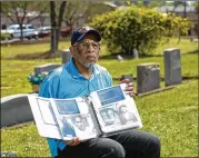  ?? JASON GETZ FOR THE AJC 2016 ?? In 2016, Charles Grogan holds a book of documents he’s collected on relatives and others at Pleasant Hill Historical Cemetery in Roswell. Pleasant Hill Baptist Church had enslaved people in its congregati­on.
