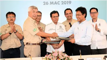  ??  ?? Shafie witnessing the exchange of documents between Jamalul and Petronas Corporate Law Department head Ahmad Redza A. Wahab after the signing of Memorandum of Agreement between the two parties.