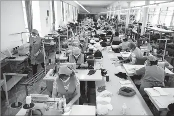  ?? EDUARD KORNIYENKO / REUTERS ?? Workers sew protective masks in a sewing shop in Kochubeyev­skoye in Stavropol region, Russia, on Tuesday.