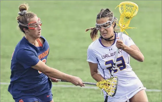  ?? Lori Van Buren / Times Union ?? Ualbany’s Katie Pascale, right, is defended by Syracuse’s Ella Simkins. Ualbany scored the first five goals of the second half, but that was after the Orange built a 12-0 lead to start the game. Pascale scored two of the goals, later adding a third in the Great Danes’ 16-6 loss at John Fallon Field.