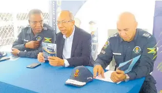  ?? PHOTO BY BRYAN MILLER ?? Incoming Commission­er of Police Dr Kevin Blake (left) speaks with Dr Horace Chang (centre), minister of national security, as Major General Antony Anderson, outgoing commission­er of police, sits by during the opening of the Hopewell Police Station, in Hanover.