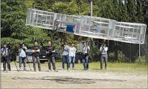  ?? AP/KOJI UEDA ?? In this photo taken in the summer of 2017, Tsubasa Nakamura, project leader of Cartivator, third from left, watches the flight of the test model of the flying car on a former school ground in Toyota, central Japan.