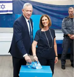  ?? (Ronen Zvulun/Reuters; Alex Kolomoisky/Pool) ?? BLUE AND WHITE leader Benny Gantz voted in Rosh Ha’ayin with his wife, Revital, before hitting the beach to call on people to vote, while Benjamin Netanyahu cast his ballot in Jerusalem and made rounds at the Central Bus Station and Mahaneh Yehuda market.