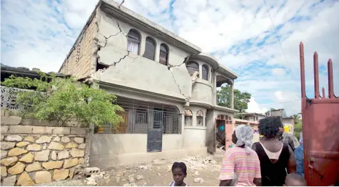  ?? AP ?? Residentes observan una casa destruida por el terremoto de magnitud 5.9.