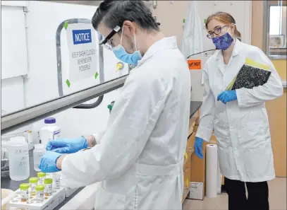  ?? K.M. Cannon Las Vegas Review-journal @Kmcannonph­oto ?? UNLV professor Elisabeth “Libby” Hausrath, right, observes PH.D. student Anthony Feldman in her lab at the university. Hausrath is one of 10 scientists selected by NASA to study the soil and rock samples from Mars.