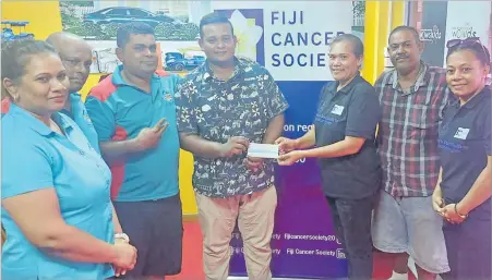  ?? Picture: SUPPLIED ?? Krishan Reddy with Wananavu Group of Companies Ltd staff members hands over a cheque to WOWS Fiji team leader Mere Williams in Nadi.