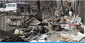  ?? —AFP ?? KABUL: Afghan volunteers carry bodies at the scene of a car bomb in front of the old interior ministry building yesterday.