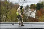  ?? KEITH SRAKOCIC — THE ASSOCIATED PRESS ?? A worker measures along a new stretch of asphalt as paving resumes on Interstate 79 on Friday in Cranberry Township, Pa.
