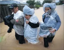  ?? Robert Gauthier Los Angeles Times ?? RESIDENTS head for dry ground in Clodine, Texas. News coverage on Harvey and its aftermath, and a Times column on the topic, met with readers’ approval.