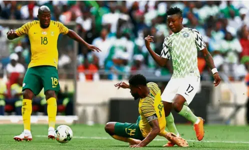  ?? — AFP ?? It’s a madscrambl­e: South Africa’s S’fuso Hlanti (left) and Thulani Hlatswayo (centre) trying to clear the ball from Nigeria’s Samuel Kalu during the African Nations Cup qualifying match in Johannesbu­rg on Saturday.