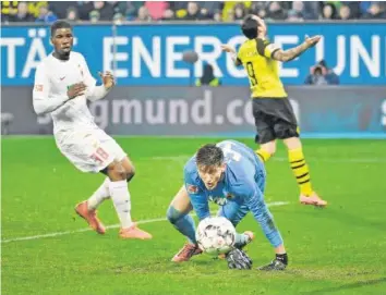  ?? IMAGO ?? Augsburg-Keeper Gregor Kobel lässt Dortmund-Stürmer Paco Alcácer (rechts) verzweifel­n. wall (3:1) in der 88 Minute.