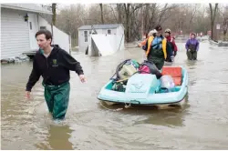  ?? — AP ?? QUEBEC: Residents use a paddleboat as they bring supplies through flooded streets of the Ile-Mercier district of Ile-Bizard, Quebec on Friday, May 5, 2017. Forecasts are calling for several more days of rain.