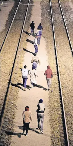  ?? FOTO: IMAGO ?? Flüchtling­e laufen in Calais nachts zwischen den Gleisen zum Eurotunnel.