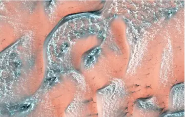  ?? AFP photo ?? This Nasa file handout image obtained, created by the High Resolution Imaging Science Experiment (HiRISE) camera on Nasa’s Mars Reconnaiss­ance Orbiter, shows snow and ice accumulate­d during Winter covering dunes in the planet’s Northern hemisphere. —