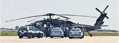  ??  ?? Greek police surround a helicopter used by rebels after they fled to Alexandrou­polis