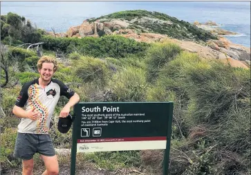  ??  ?? AT THE END: Tom Dunn celebrates the end of his journey from Australia’s northernmo­st point to its southernmo­st point. Dunn biked, ran and kayaked in what he dubbed ‘Australia’s Longest Triathlon’.