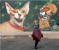  ?? Reuters ?? A mural showing Frankie the mouse putting a leash on a Pharaonic cat is painted by a Polish graffiti artiste. —