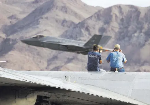  ?? ERIK VERDUZCO/LAS VEGAS REVIEW-JOURNAL FOLLOW @ERIK_VERDUZCO ?? Spectators on top of a Consolidat­ed PB4Y-2 Privateer from World War II watch an F-35 take to the skies during Aviation Nation at Nellis Air Force Base on Saturday. The event continues Sunday with gates opening for security checks at 9 a.m.