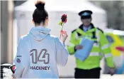  ??  ?? A forensics team investigat­es at the scene of a stabbing in Morning Lane, Hackney, above; a girl brings a single red rose to the place where a 20-year-old man was stabbed and killed, also in Hackney