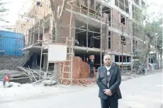  ?? — AFP ?? Lawyer Naresh Gupta poses outside an under-constructi­on building.