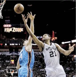  ??  ?? Tim Duncan tira por debajo del brazo de Nick Collison para darle dos puntos a los Spurs de San Antonio.