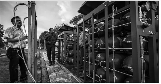  ?? ANUPAM NATH / ASSOCIATED PRESS ?? P V R Murthy, center, general manager at Oil India Limite, shows part of a hydrogen plant on Aug. 17 in Jorhat, India. Green hydrogen is being touted around the world as a clean energy solution to take the carbon out of high-emitting sectors.