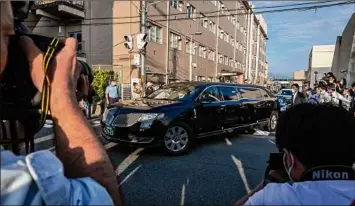  ?? Yuichi Yamazaki / Getty Images ?? A car believed to be carrying the body of Japan former Prime Minister Shinzo Abe on Saturday leaves Nara Medical University Hospital in Kashihar. Abe was pronounced dead after being shot in the back while campaignin­g at Yamatosaid­aiji Station.