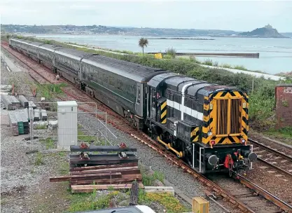  ?? Steve Donald ?? On June 20, No. 08645 leads 5C50 19.40 Longrock T&RSMD-Penzance at Ponsandane footbridge, with No. 57604 at the rear, and St Michael's Mount in the background. The ‘08' sees occasional use with ‘Night Riviera' ECS movements.