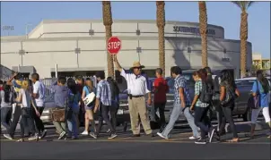  ??  ?? Security guard Mike Gutierrez holds a stop sign as he helps students cross Ocotillo Drive on 22nd Street on the first day of school at Southwest High School in El Centro in 2011. The free summer meals will be prepared at CUHS and delivered to SHS....