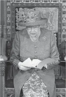  ??  ?? The Queen makes a speech in the House of Lords at the ceremonial opening of Parliament in London on Wednesday. She wore a blue hat dotted with a circle of yellow-centred flowers that prompted many on social media to suggest that she was offering a nod...