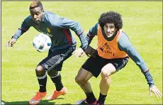  ??  ?? Belgium’s national football team player Divock Origi (left), and Marouane Fellaini (right), vie for the ball next to team coach Marc Wilmots, during a training at the Juan-Antonio-Samaranch on May 25, in Lausanne. The Belgian team is in Lausanne for a...