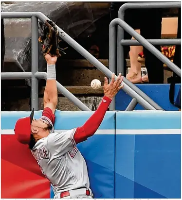  ?? JAYNE KAMIN-ONCEA / GETTY IMAGES ?? Chase Utley’s solo homer in the fifth inning Sunday glances off the glove of Reds center fielder Billy Hamilton. It brought the Dodgers within 4-3, but the Reds responded with three runs in the sixth.