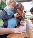  ??  ?? An einem Stand ritzen die Kinder ihre Namen in Holzbrettc­hen.