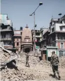  ??  ?? RUBBLE. Nepalese soldiers inspect debris at the historical heritage site yesterday.