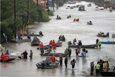  ??  ?? TOP: Rescuers in boats fill Tidwell Road on Monday as they help flood victims evacuate as floodwater­s rise in Houston.