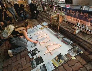  ?? PETER PARKS/GETTY-AFP ?? A protester lights candles Monday on the campus of the Chinese University of Hong Kong.